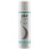 Pjur Woman Nude Waterbased Lube 100ml bottle with clear liquid and white label on a soft surface.