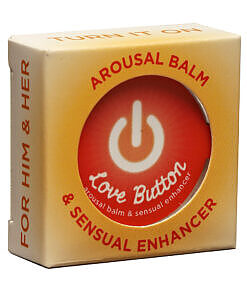 Earthly Body Love Button Tin .3oz arousal balm tin on a nightstand with subtle warm lighting.