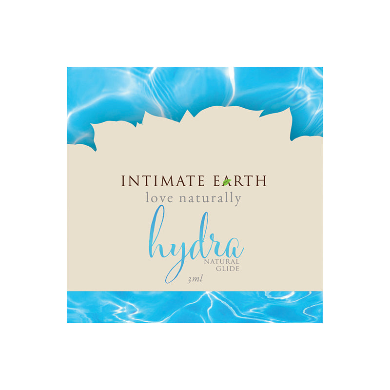 Intimate Earth Hydra Natural Glide 3 ml foil packet displayed next to a ruler for scale with clear gel texture visible.