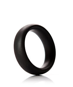 Tantus Beginner C-Ring 2 inch Onyx silicone ring laying on a smooth white surface