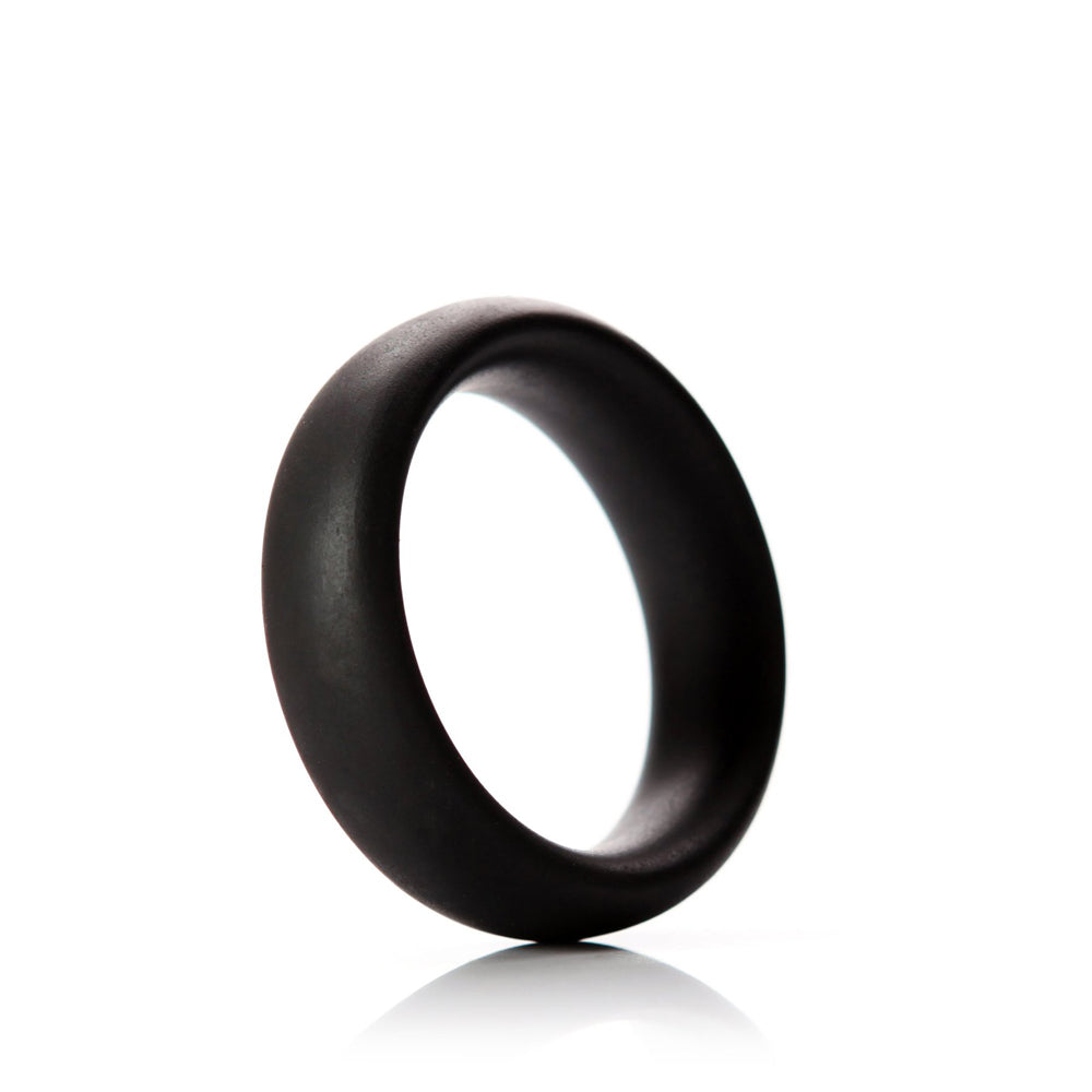 Tantus Beginner C-Ring 2 inch Onyx silicone ring laying on a smooth white surface