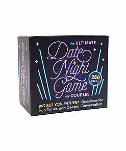 The Ultimate Date Night Game for Couples box beside fanned-out cards on a cozy table setting