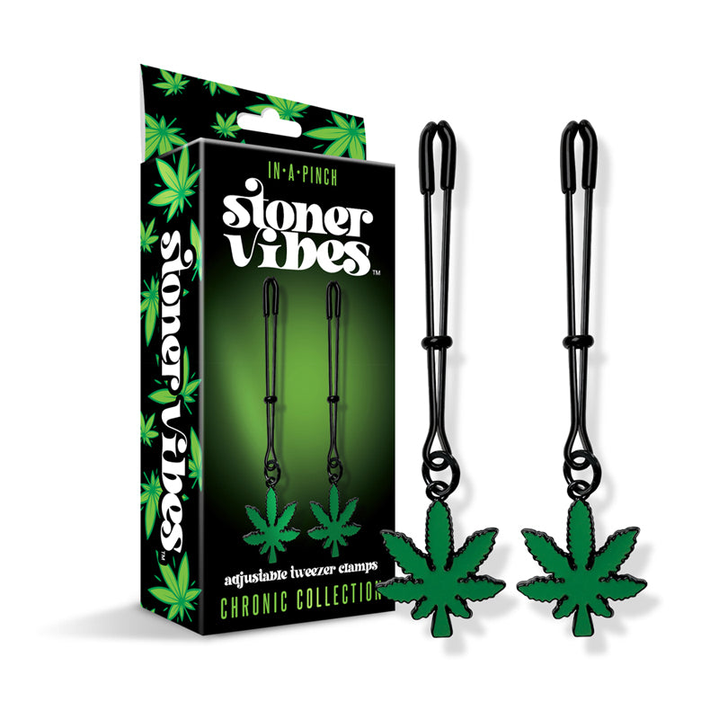 Silver tweezer nipple clamps with green cannabis leaf charms on a dark background.