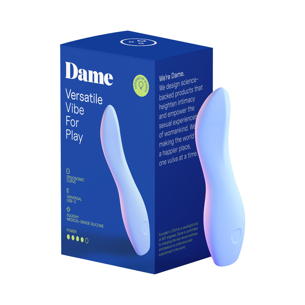 Dame Dip 2.0 Classic Vibrator in periwinkle blue sitting next to its magnetic USB-C charger on a white background.