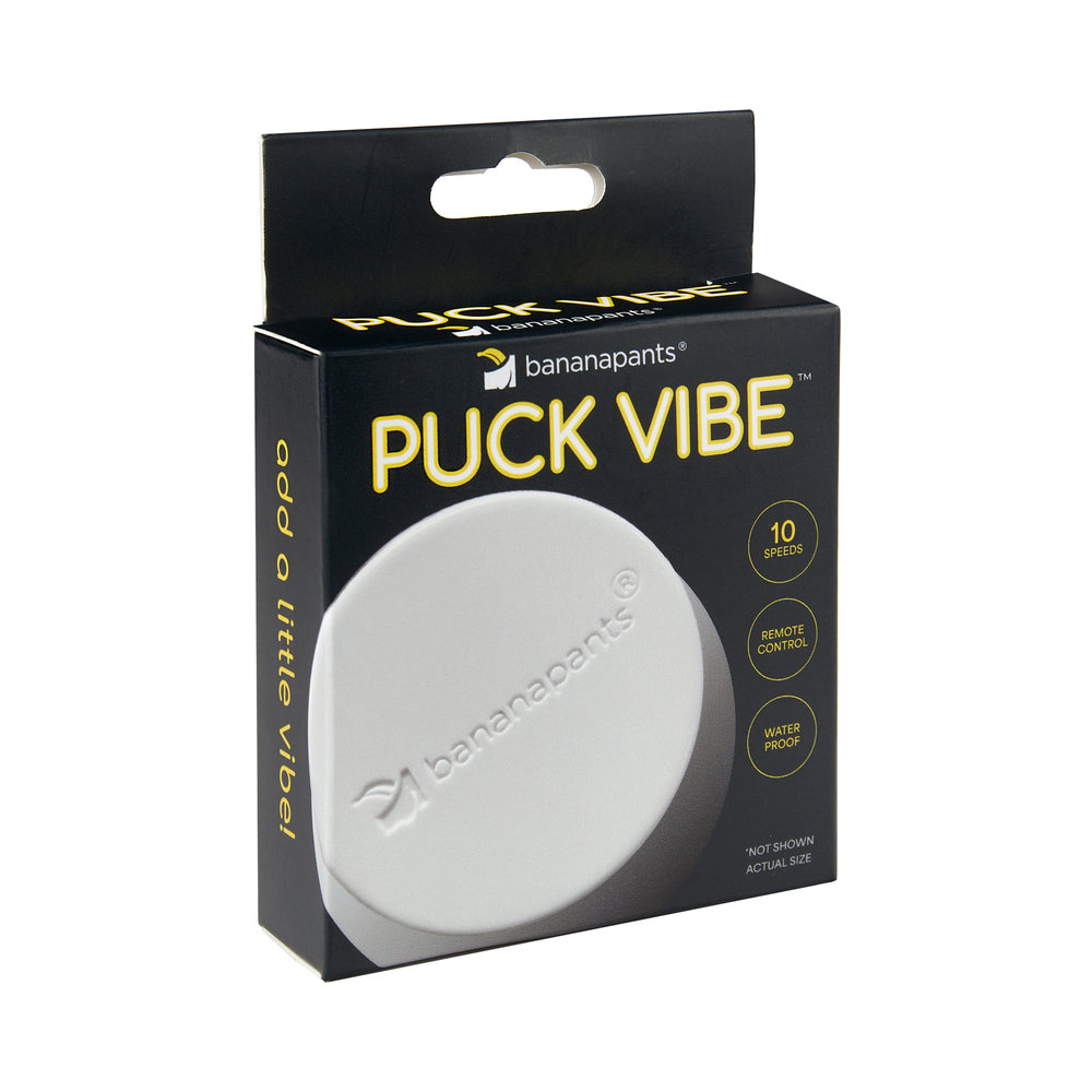 Banana Pants Puck Vibe White/Black bullet vibe with remote control and magnetic USB charger on a dark background
