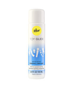 pjur TOY GLIDE 3.4 oz water-based lubricant bottle beside a colorful silicone toy on a soft surface