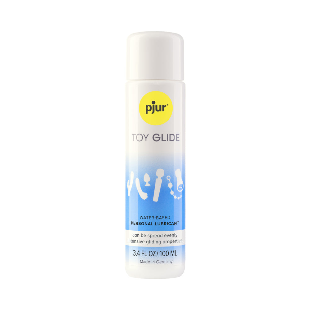 pjur TOY GLIDE 3.4 oz water-based lubricant bottle beside a colorful silicone toy on a soft surface