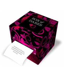 Close-up of the Box of Dares couples game cards spread on a cozy blanket with a romantic candle-lit backdrop.