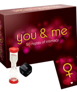 You & Me Game set with red and blue dice on a white scorepad beside candlelight.