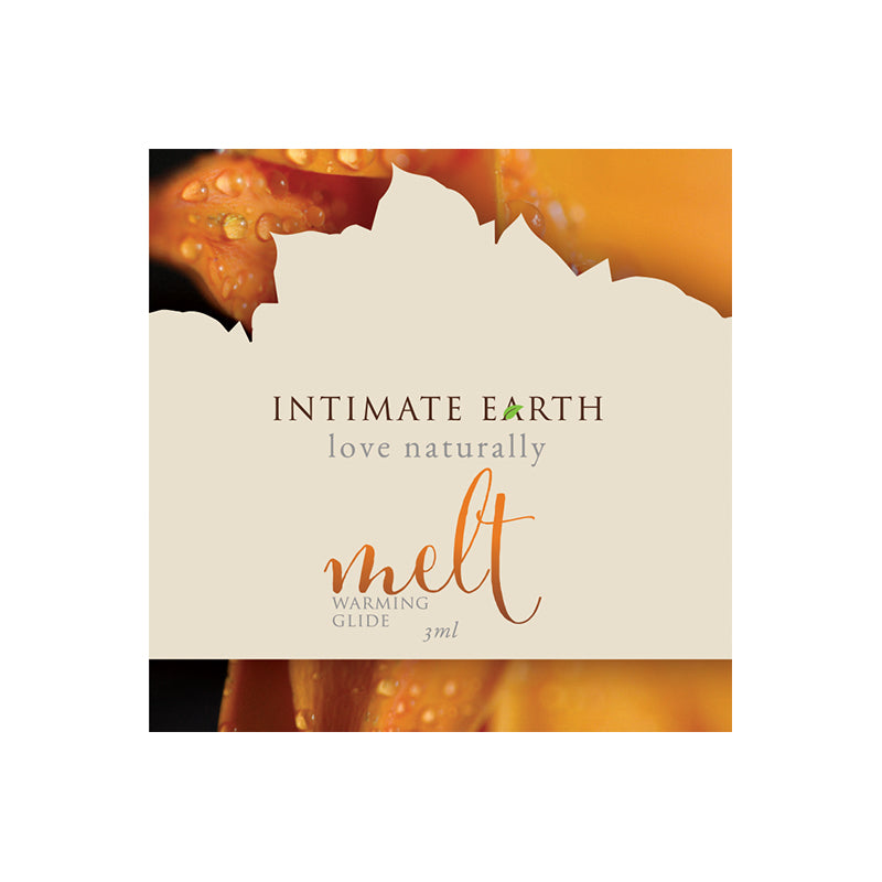 Intimate Earth Melt Warming Glide 3ml foil packet on a neutral background with cinnamon stick accent.