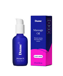 Dame Sex Oil Massage Oil 2 oz bottle beside a smooth stone and candle