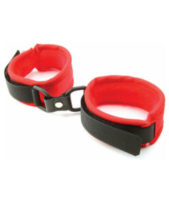 Red faux fur handcuffs with soft plush lining and polished metal connectors on a dark background