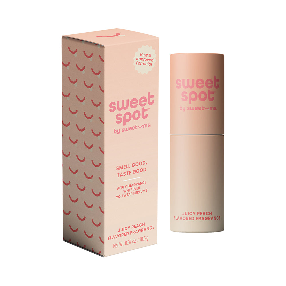 Sweetums Juicy Peach Flavored Fragrance stick on a peach-toned background