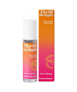 Love to Love Thrill Delight Pleasure Elixir 0.33 oz roll-on bottle on satin fabric beside a fresh coconut