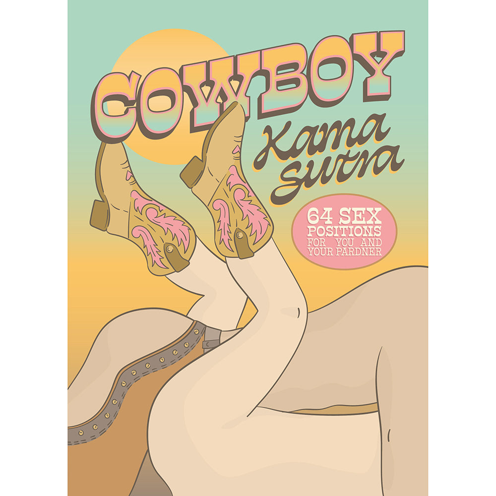 Cowboy Kama Sutra hardcover book with humorous cowboy illustrations open on a table next to a cowboy hat.