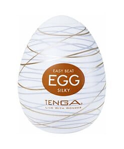 Tenga Egg Silky white egg-shaped masturbator case next to the soft elastomer sleeve with silky interior ridges on a plain surface.